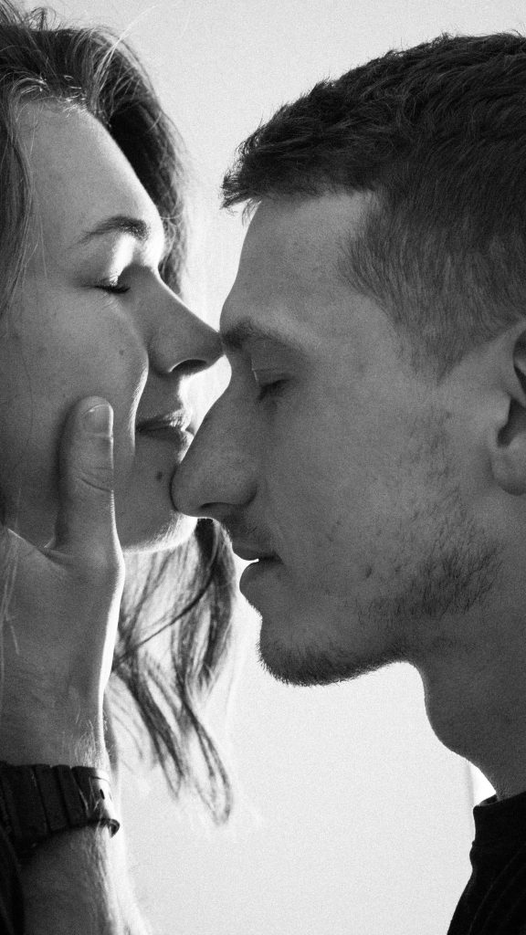 Black and white portrait of intimate couple with closed eyes sharing a moment.