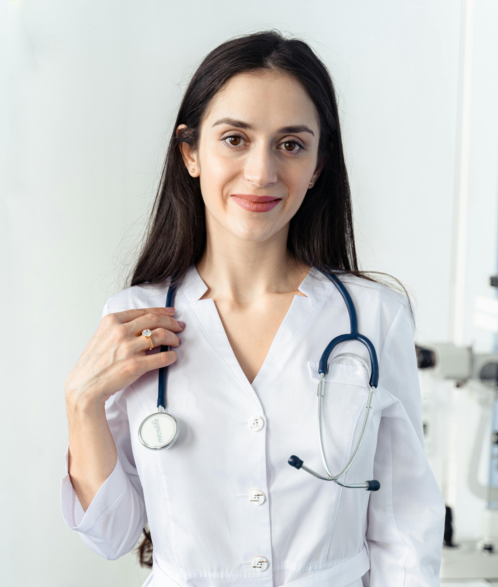 Portrait of a smiling female healthcare worker in a white coat with a stethoscope, embodying professionalism and care.