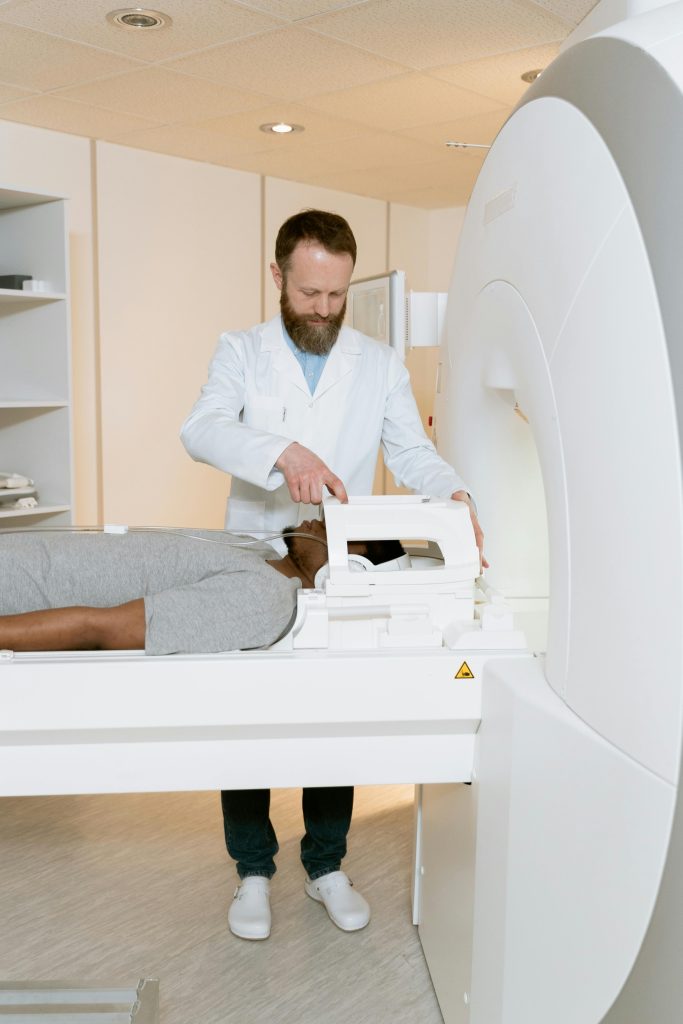 A doctor operates an MRI scanner for a patient examination in a healthcare facility.